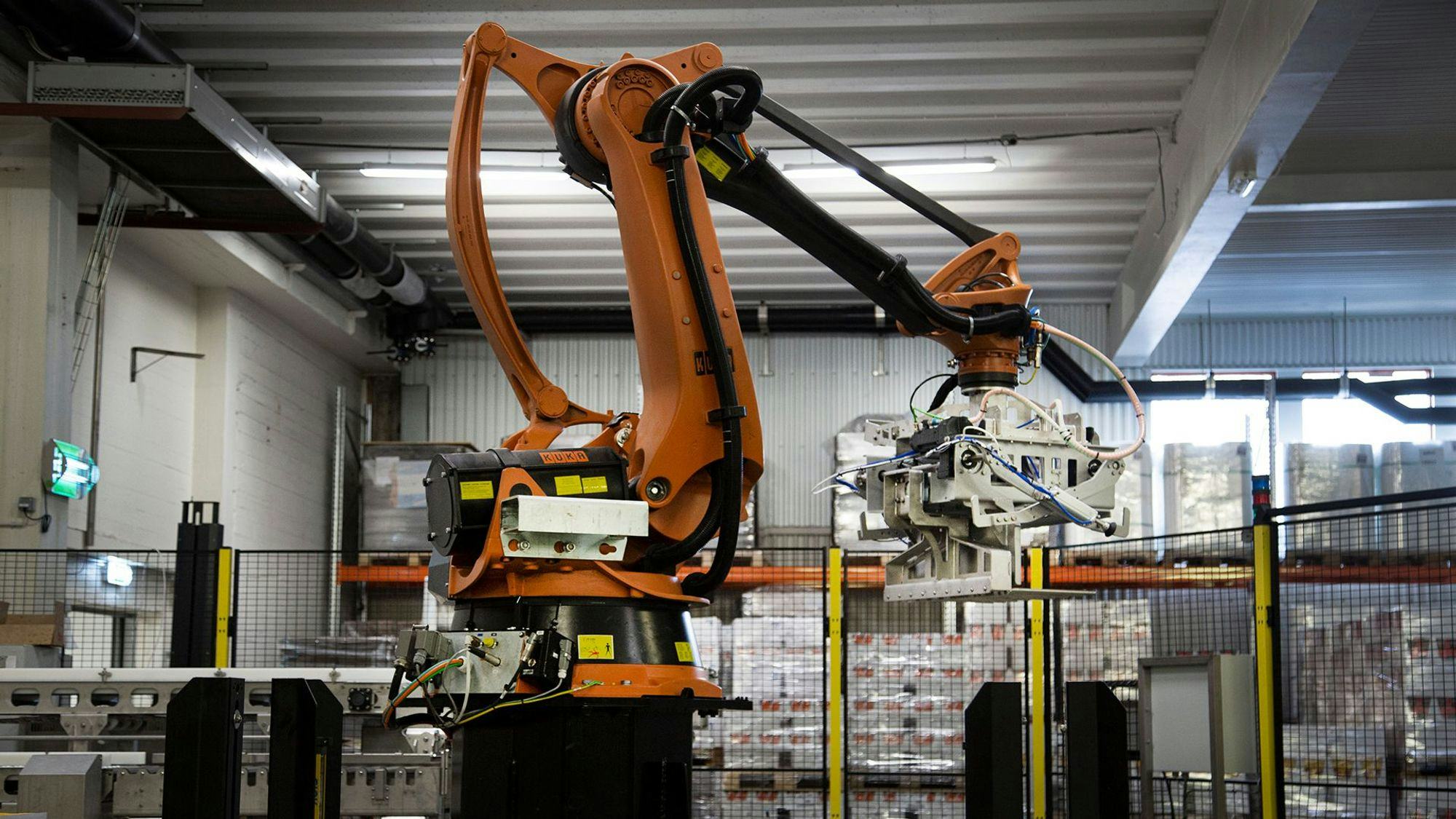 Factory orange robot at work, located in a warehouse