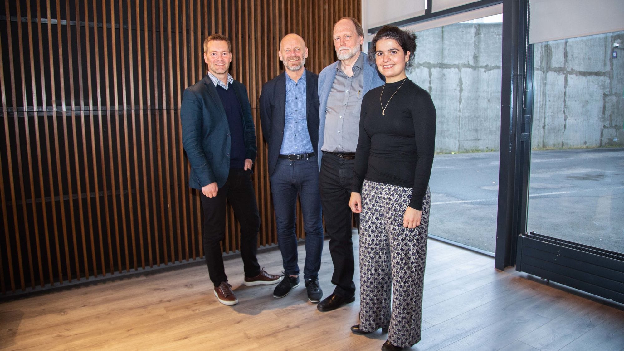 Four individuals posing for picture in an office setting
