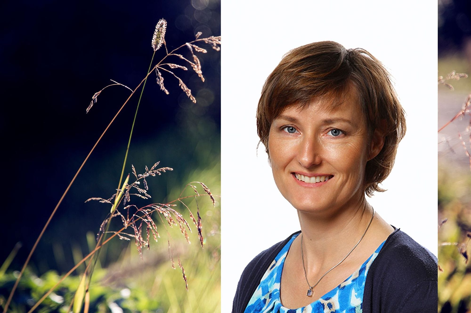 A smiling woman portrait set against a blurry background that includes plant