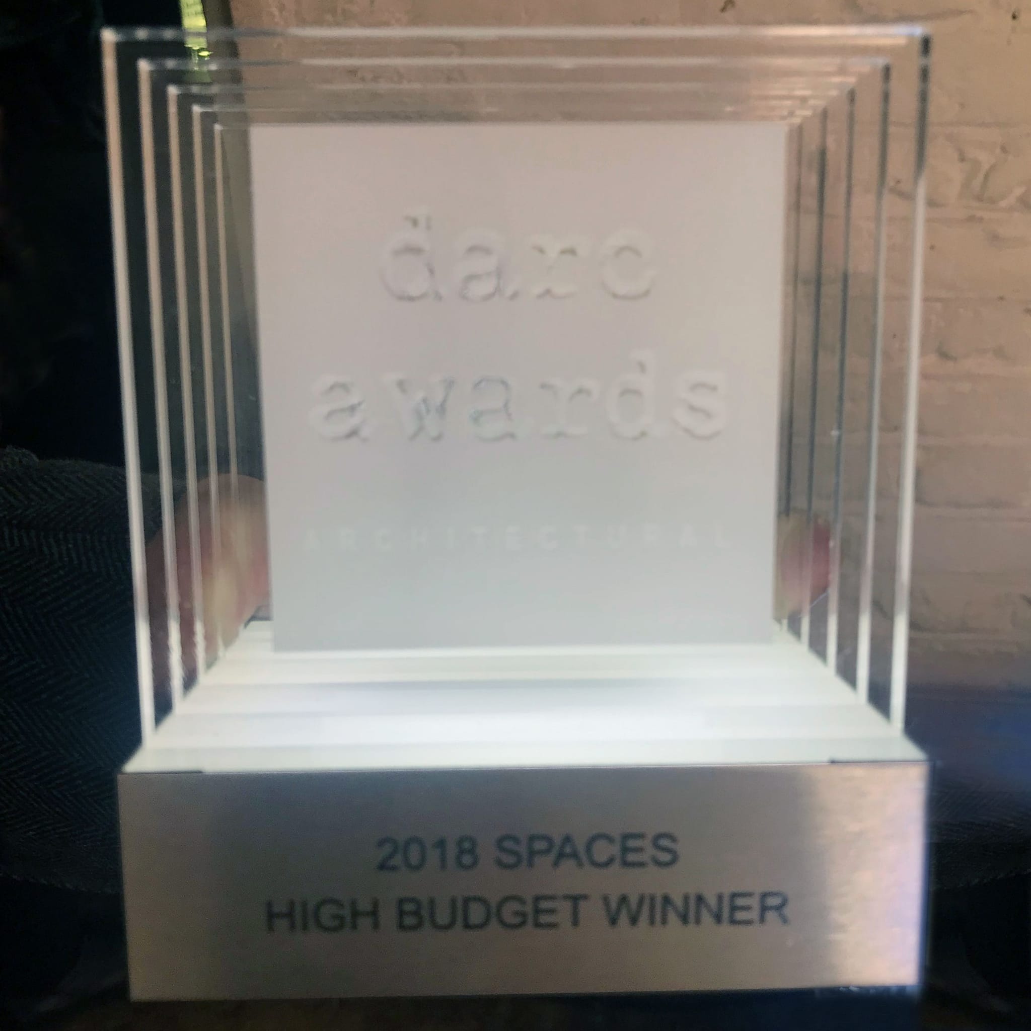 An award made of clear glass with text "darc award" engraved into it
