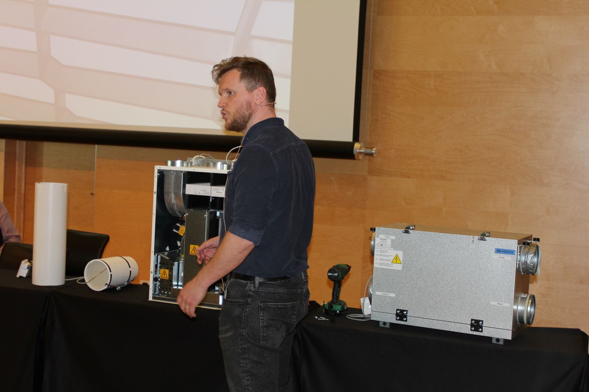 A man demonstrating standing next to equipment