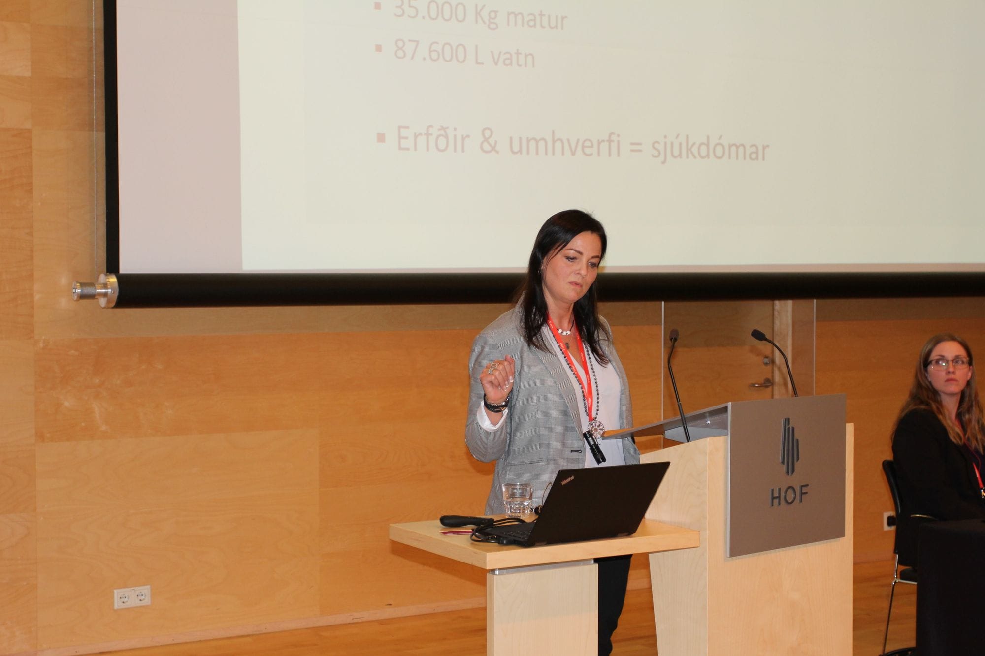 A women giving presentation watching a black laptop