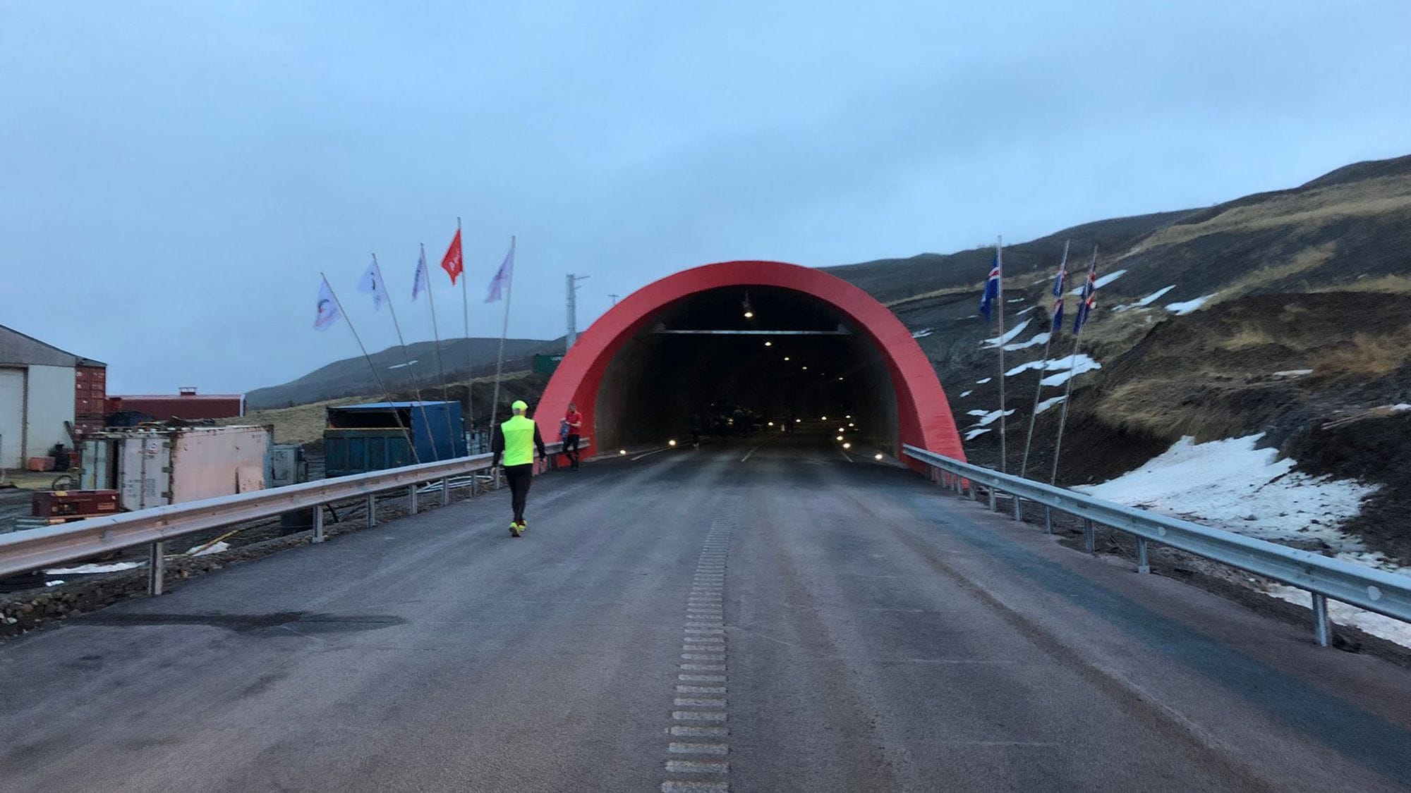 Two individuals walking towards the entrance of a tunnel