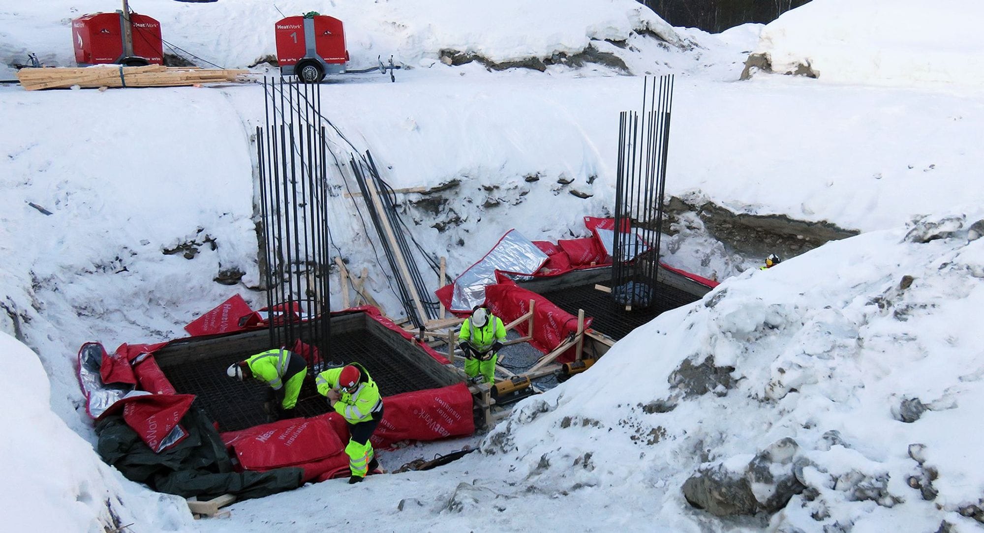 Fólk vinnur við uppsetningu raflínumasturs að vetrarlagi.
