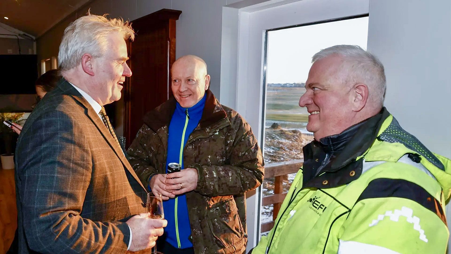 Þrír menn ræða saman í boði.