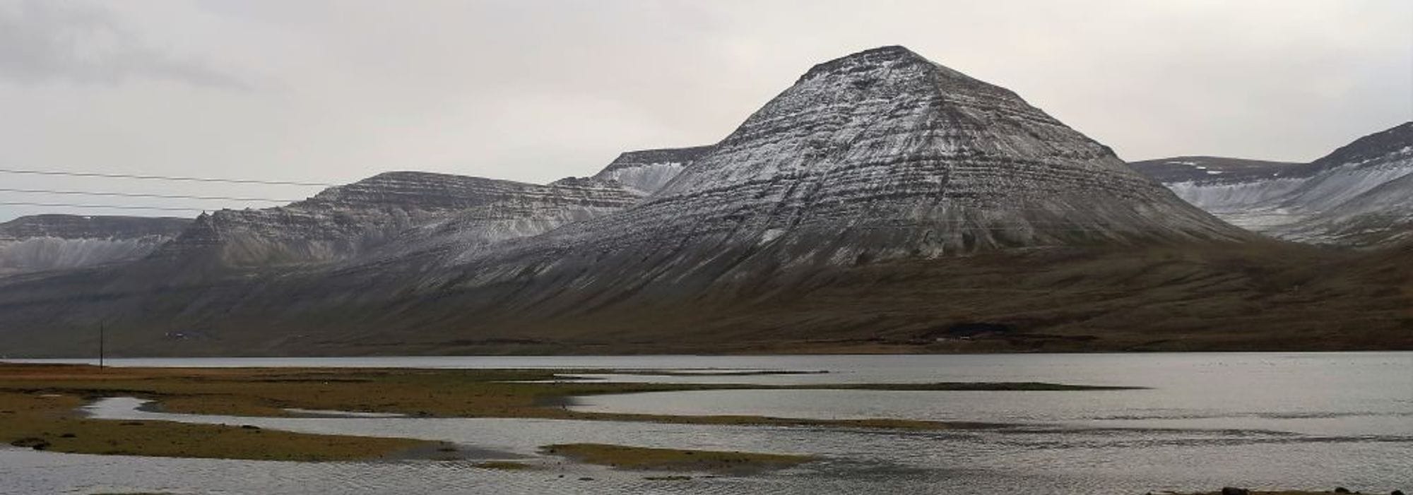Snow stripped mountain with a flat foreground appeared to be wetland