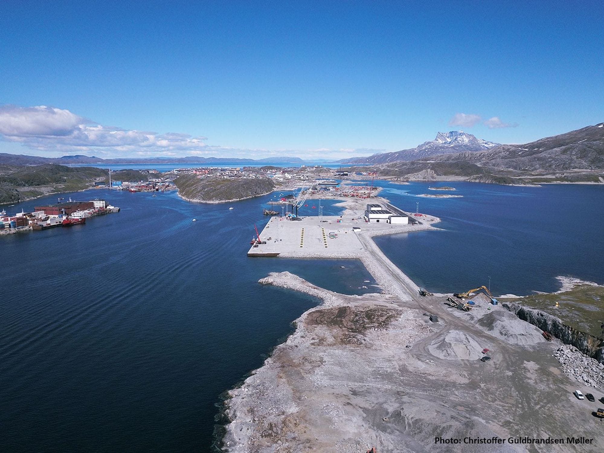 Hafnarmannvirki með fjöll í baksýn.