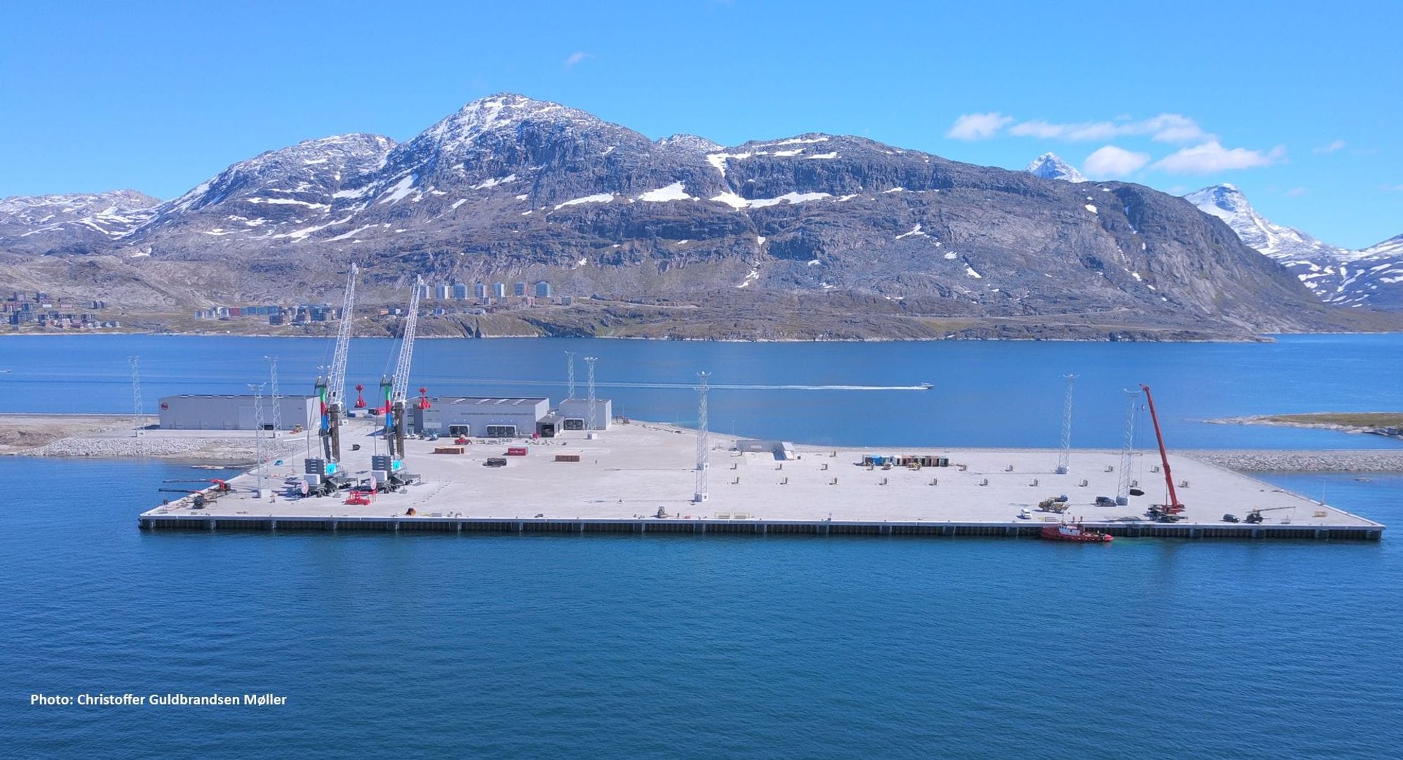 Hafnarmannvirki með fjöll í baksýn.