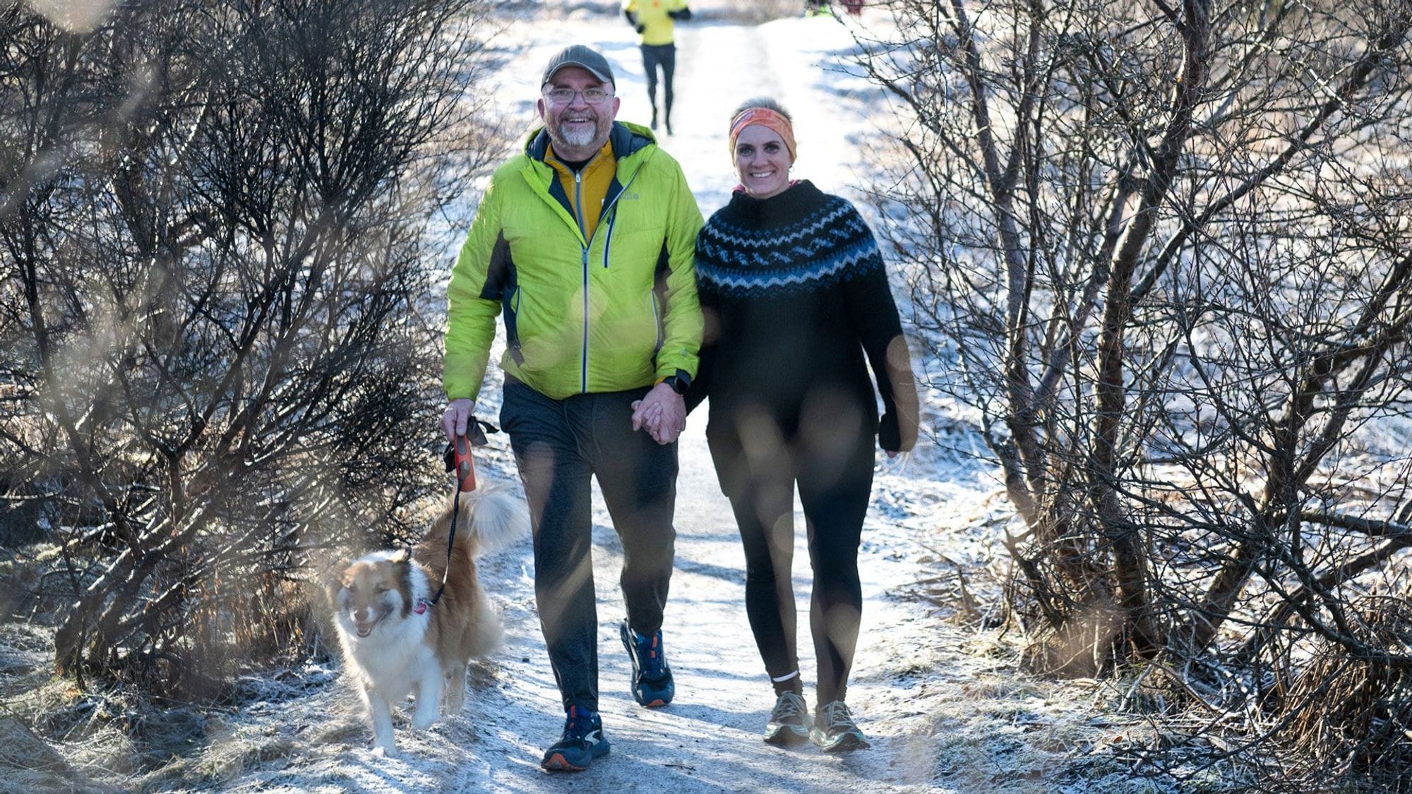 Maður og kona á gangi með hund.