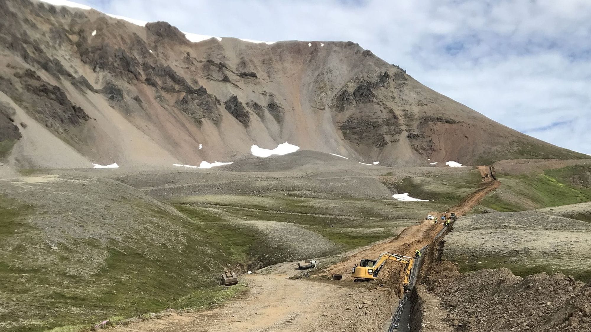 A construction equipment working on a pipeline or a road in a mountain terrain 