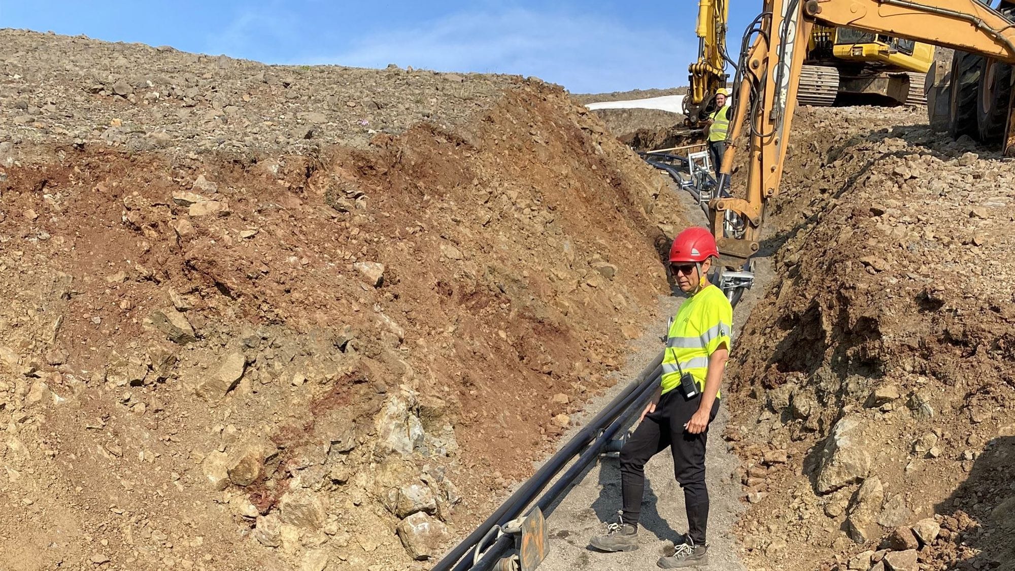A construction worker overseeing the installation of pipes