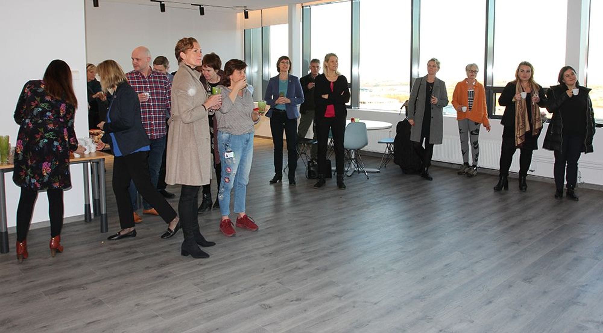 Casual gathering of individuals standing and conversing in a room