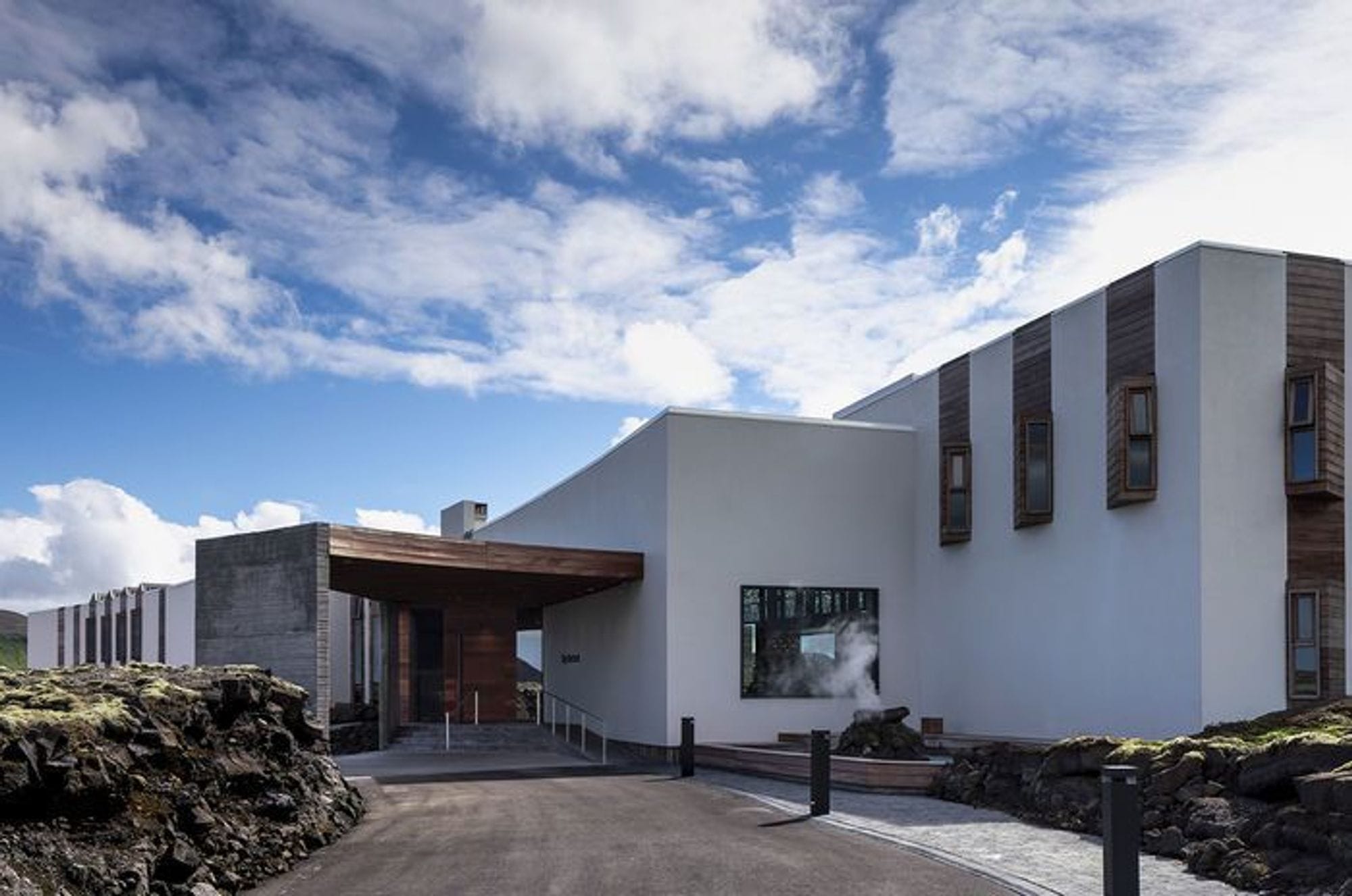 A modern white building under a partly cloudy sky