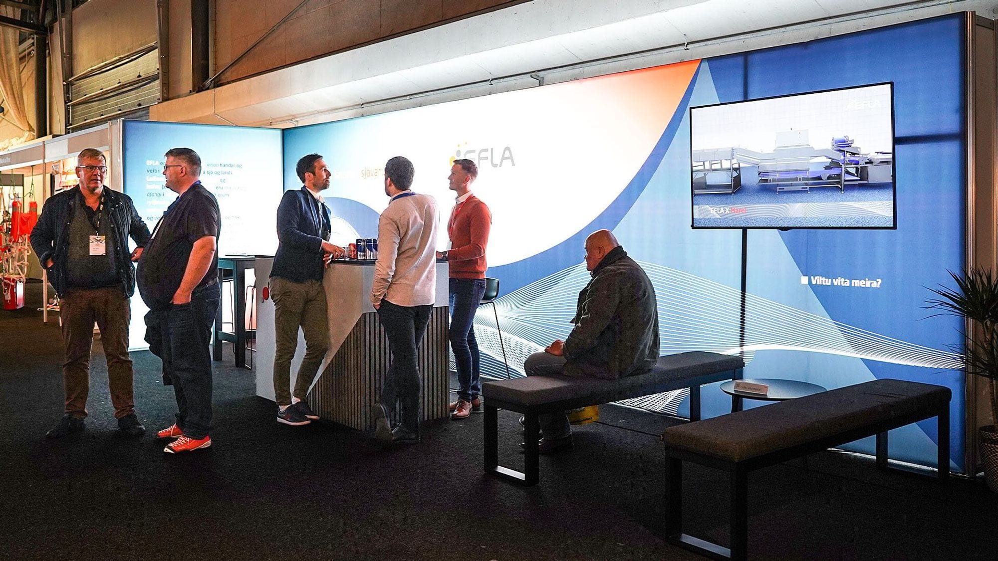 A group of people at a promotional booth of EFLA with bright screens