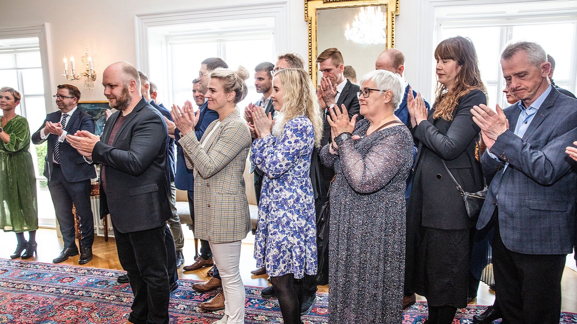 A group of men and women smiling and applauding