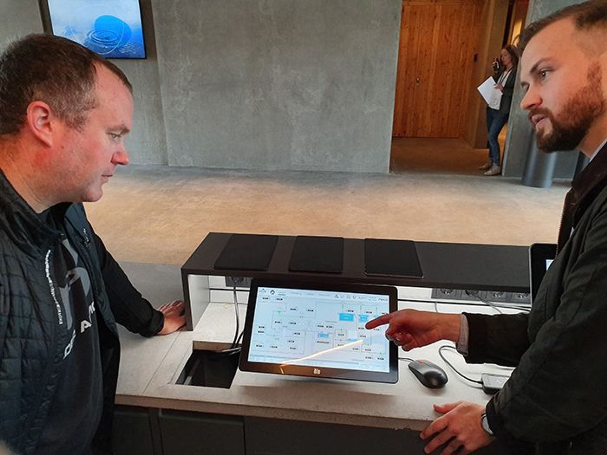two men discussing about the content of an iPad 