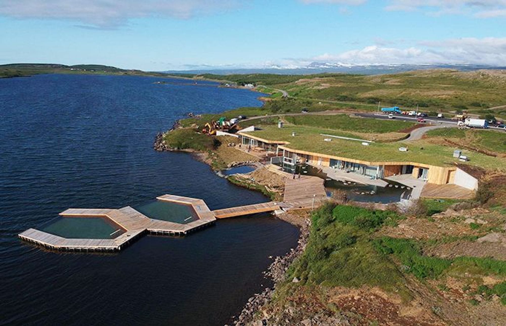 Geothermal bath facility nestled along the edge of a blue lake 