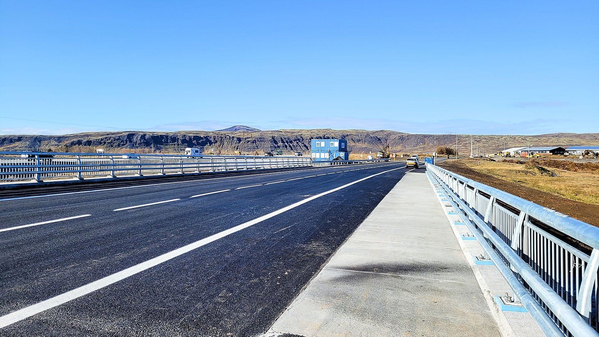 A highway with multiple lanes, clear road marking and pedestrian path to the side 