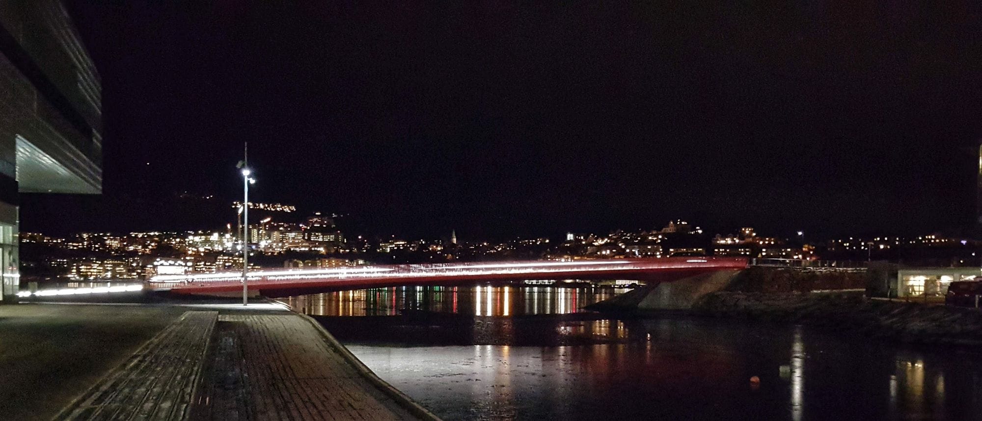 A view of city with illuminated buildings and bridge at night