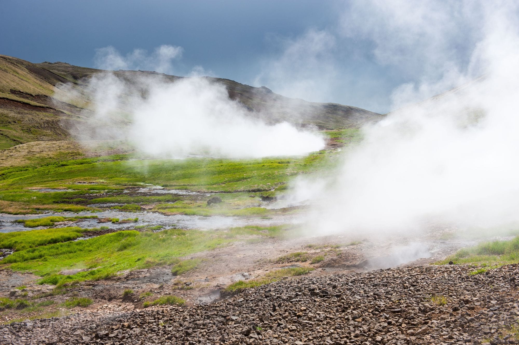 Steam rising from green and gravel field