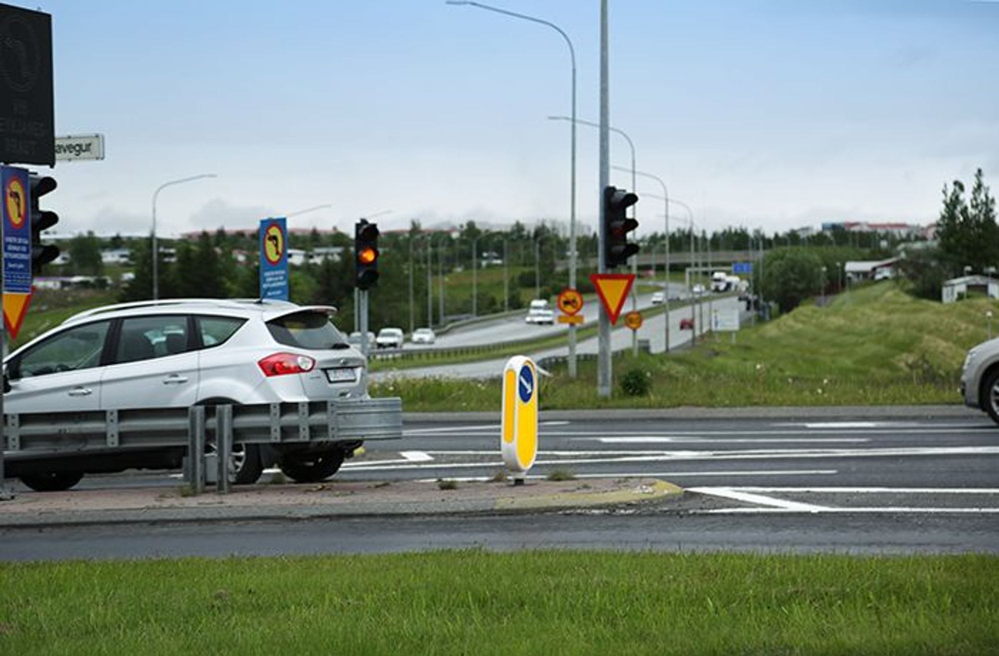 A silver car stopped at traffic lights