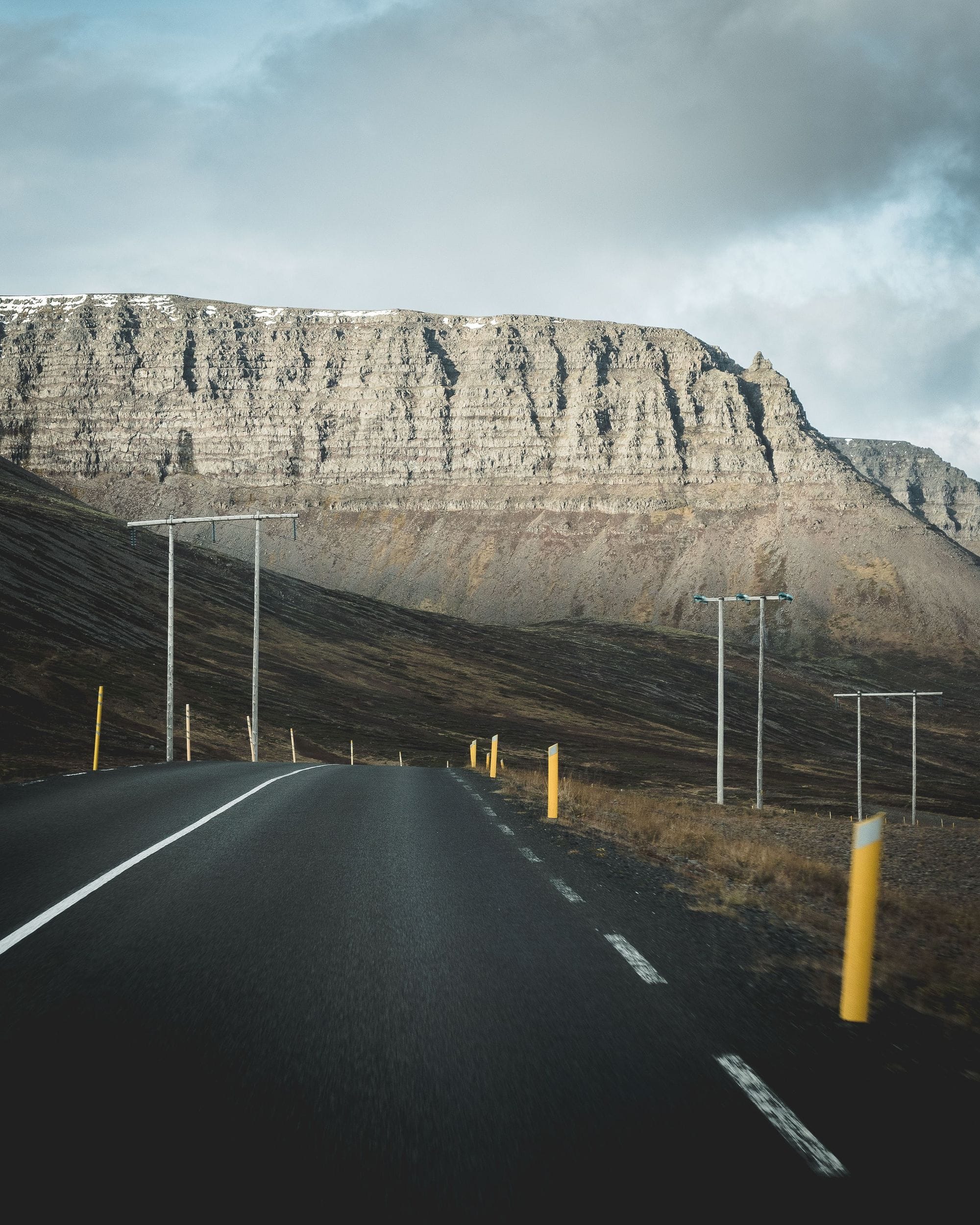 a road leading to mountains and power masts