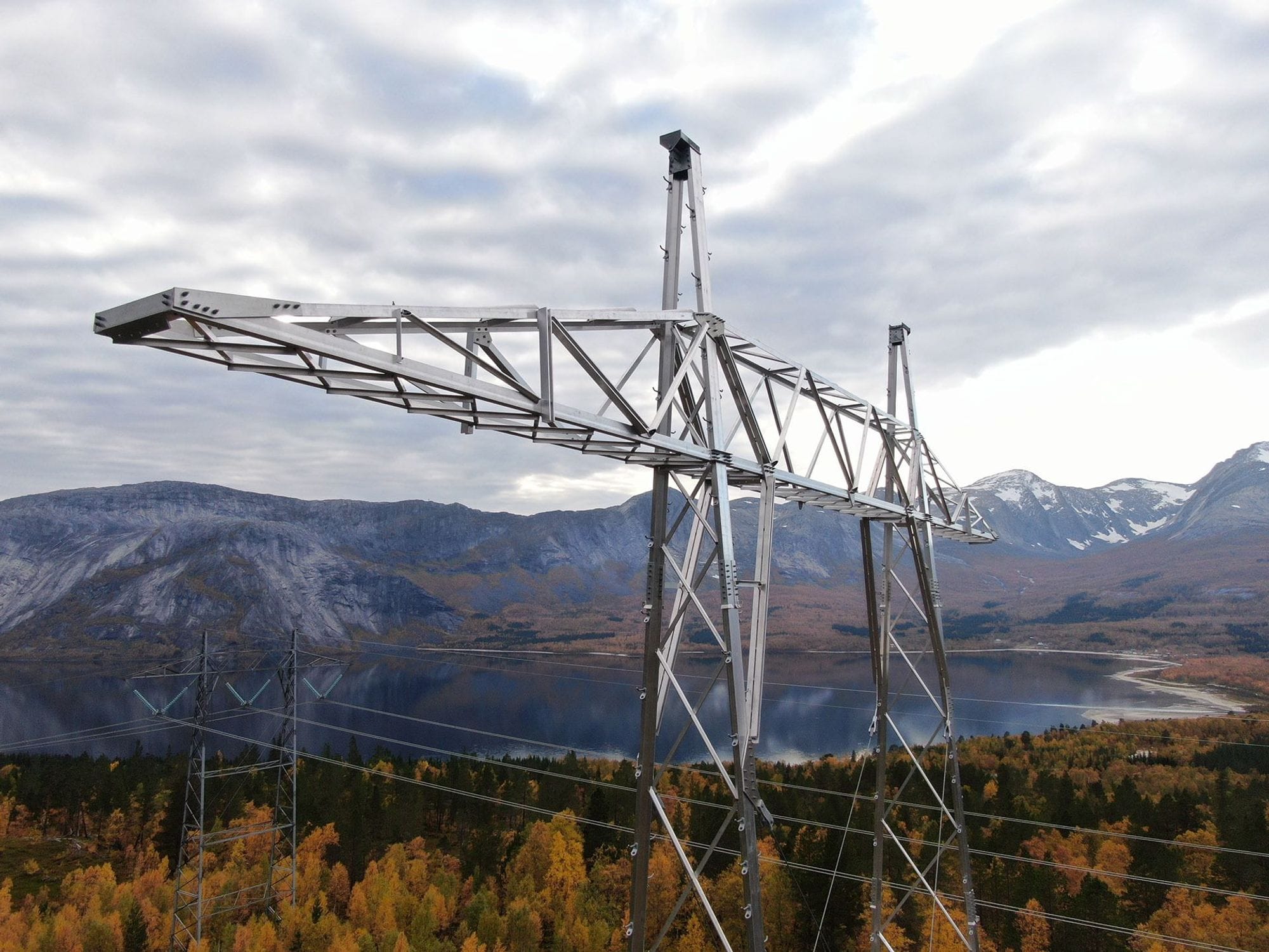 A large electricity pylon with mountainous landscape in the background