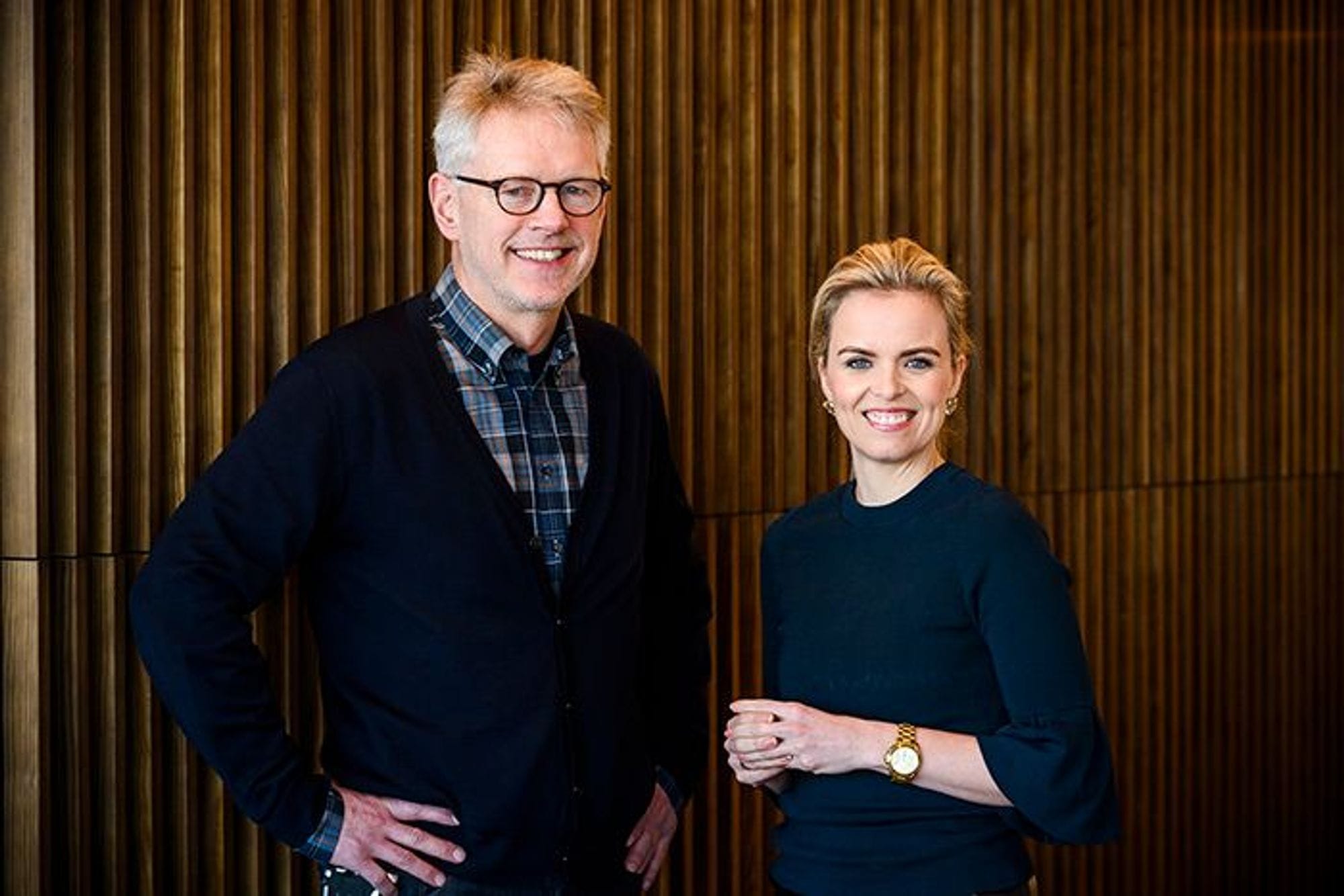 A man and a women standing with a smile and posing for the camera