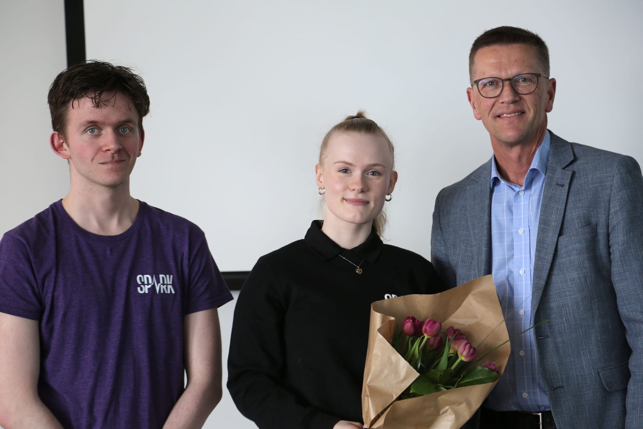 Uppstillt mynd af fólki með blóm.