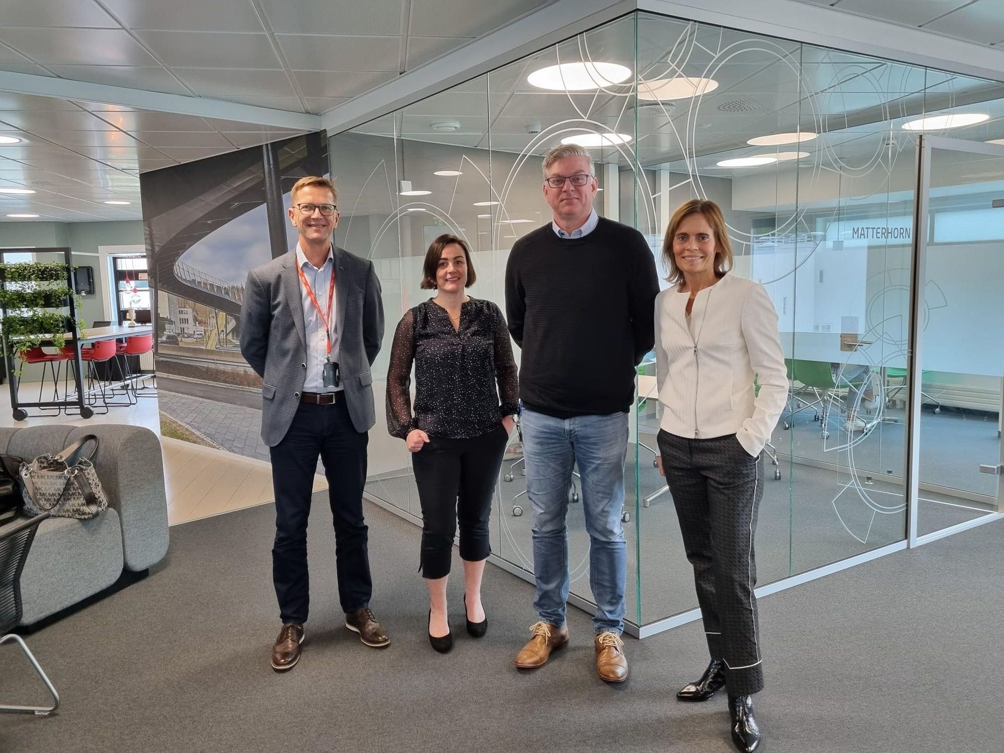 Four individuals posing for picture in an office setting