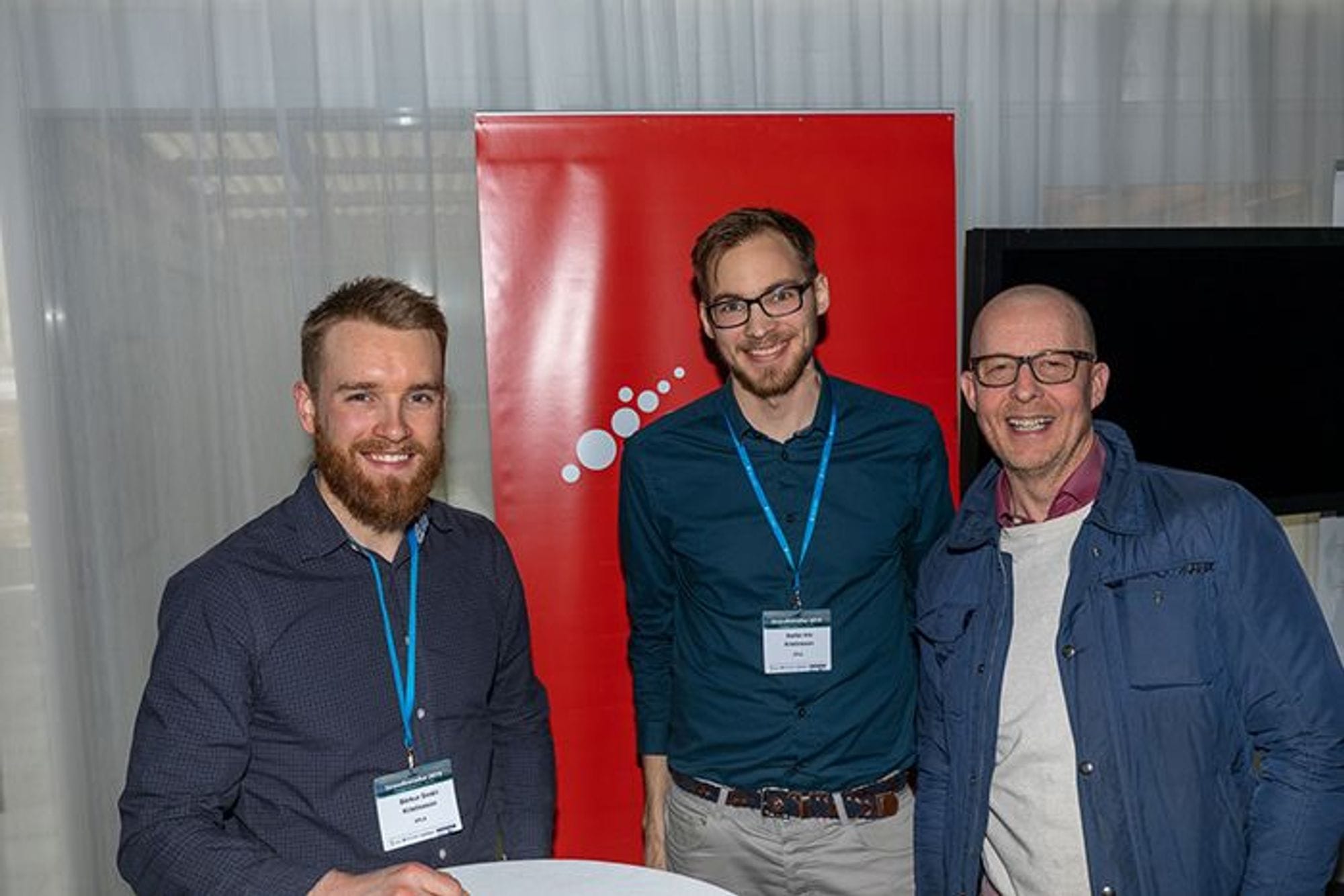 Three men smiling and posing