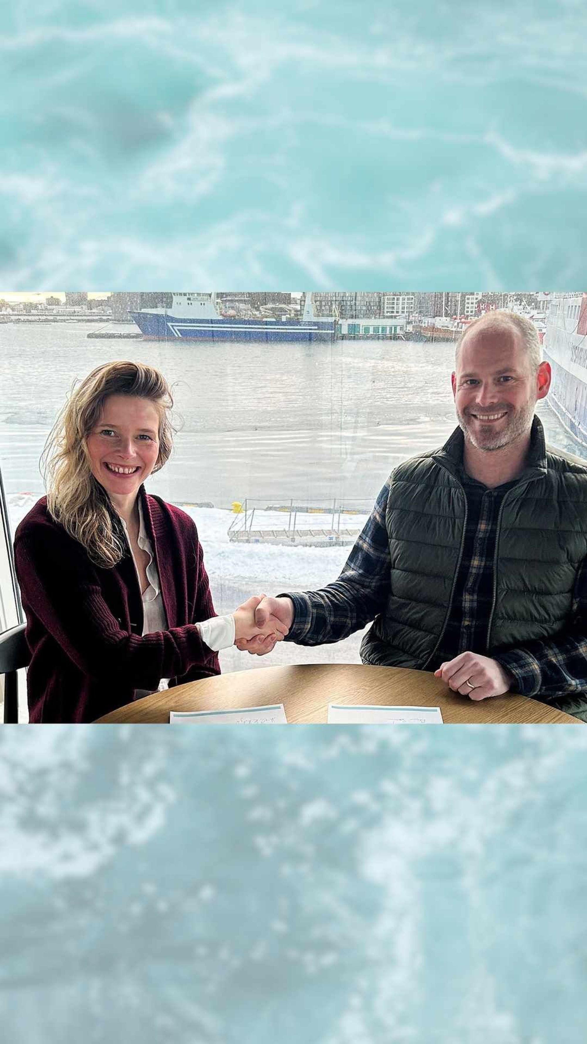 Kona og maður takast í hönd og brosa