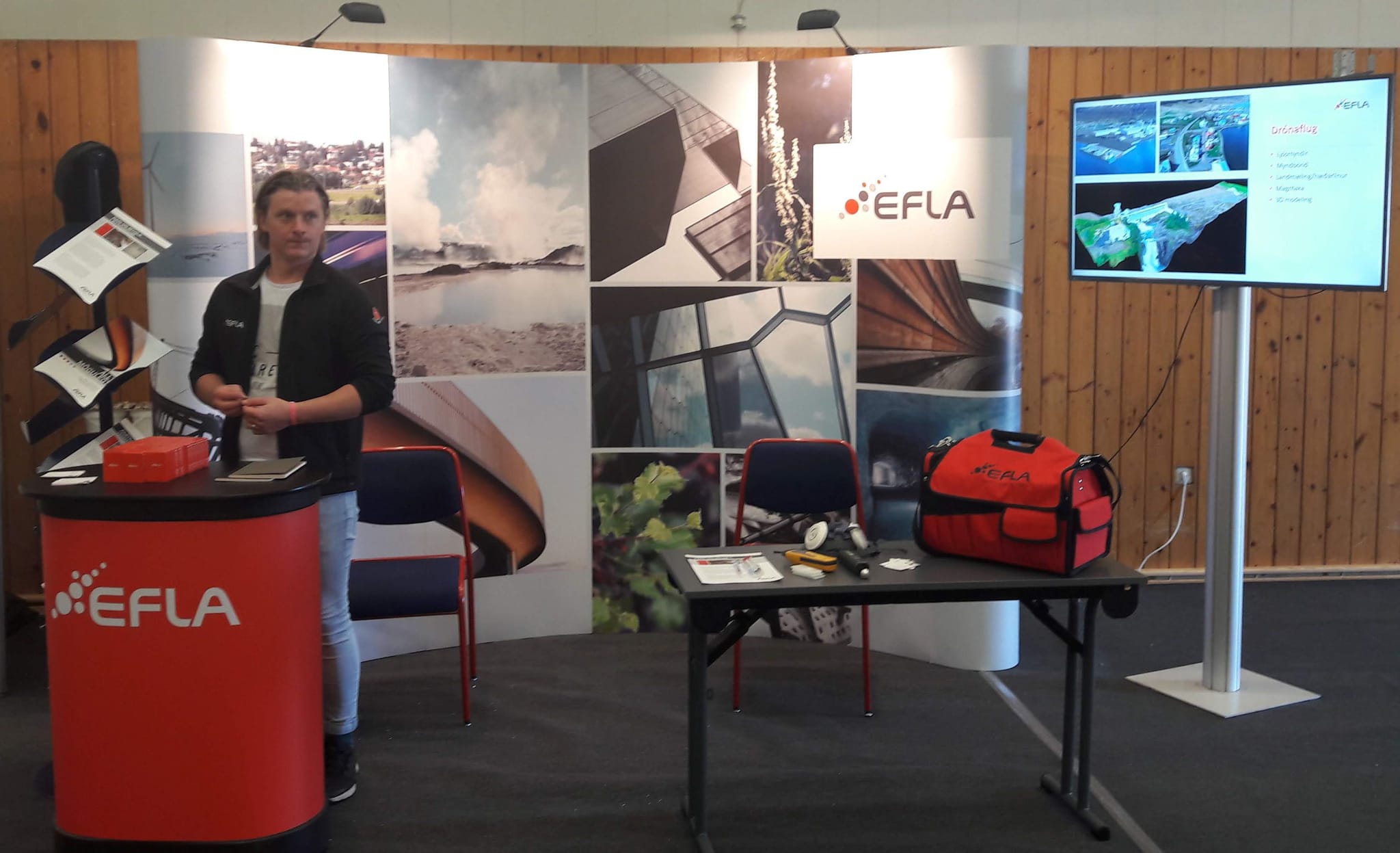 promotional booth with a person standing behind a red counter 