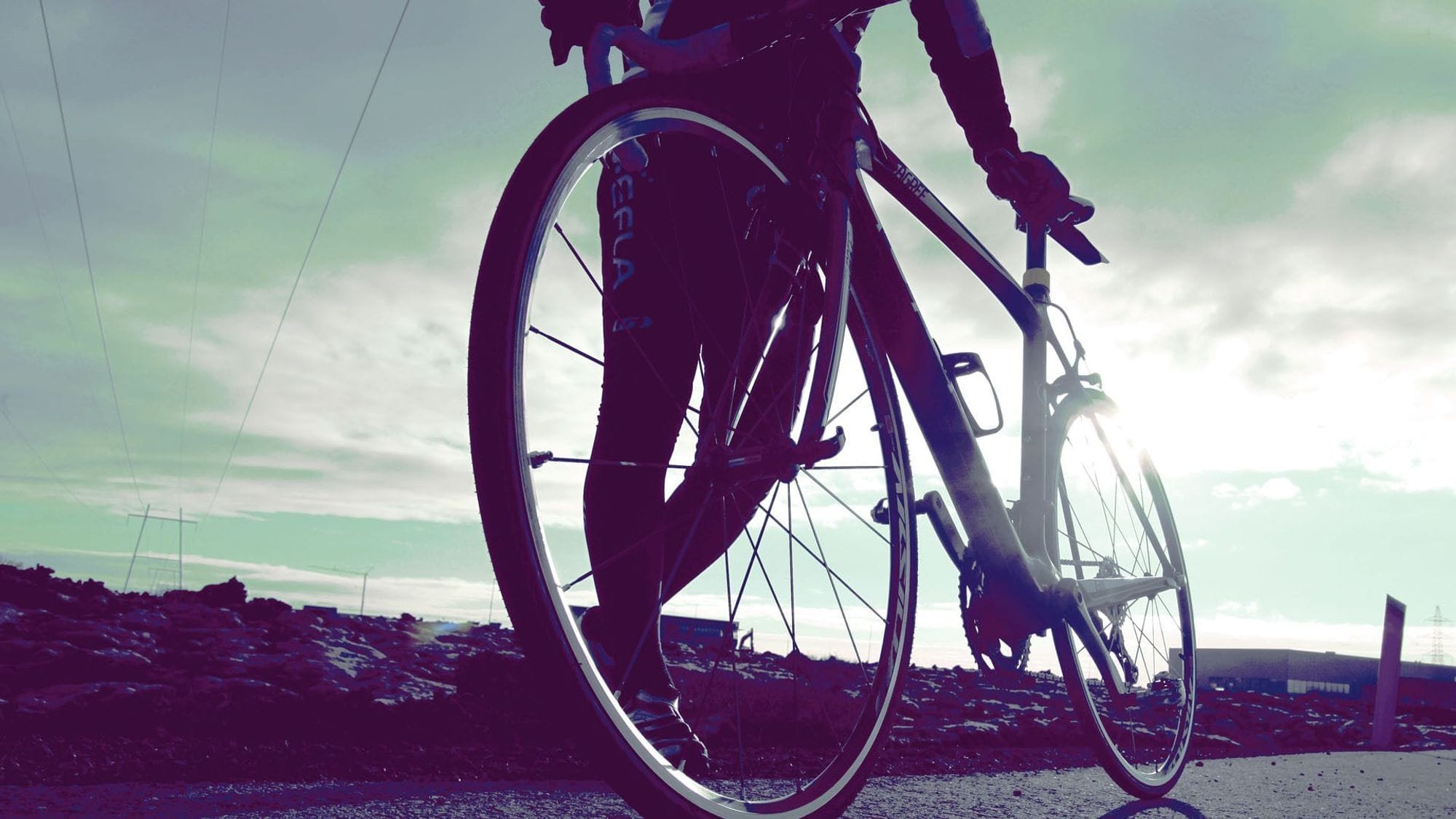 A close up photo of a person with a bike from a low and back angle