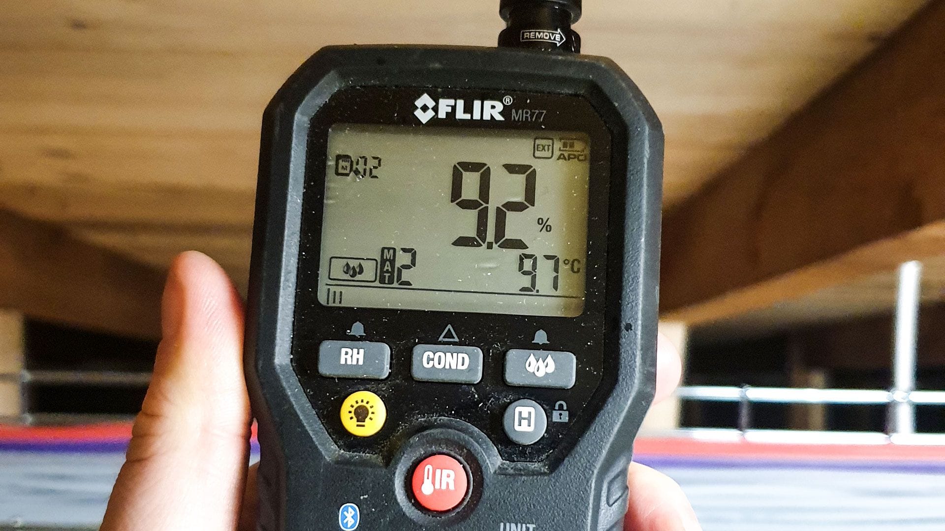 A device that measures temperature being held in someone's hand