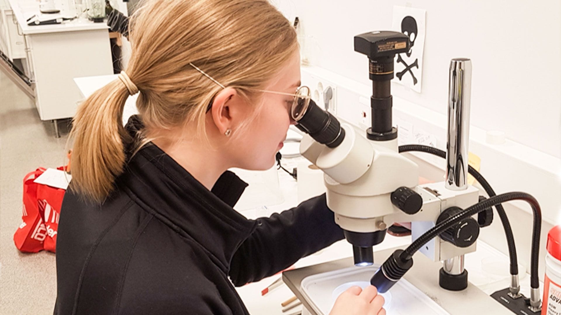 A woman looking into a microscope 
