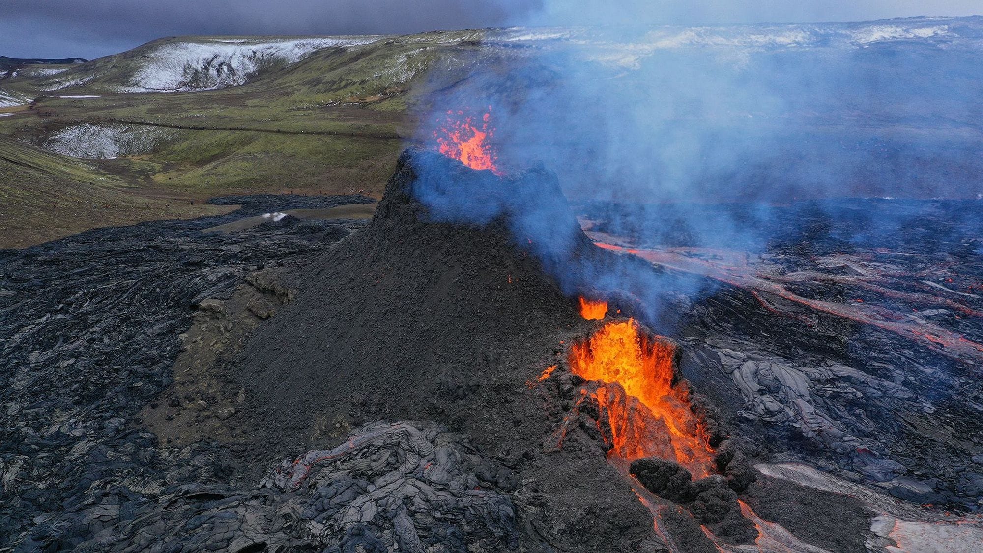 An active volcano eruption with lava flowing down the terrain, emitting smoke