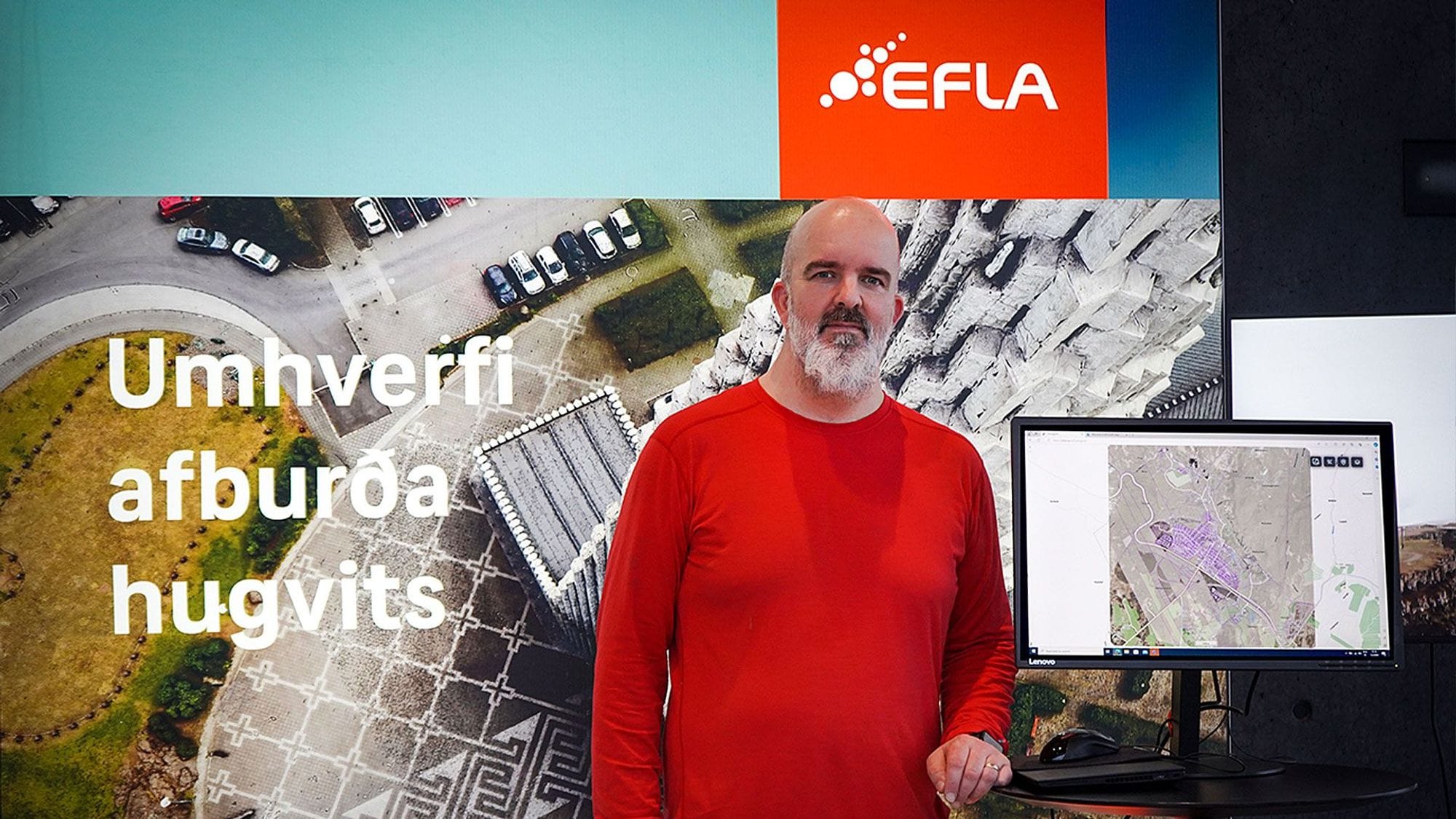 Maður fyrir framan kynningarspjald.