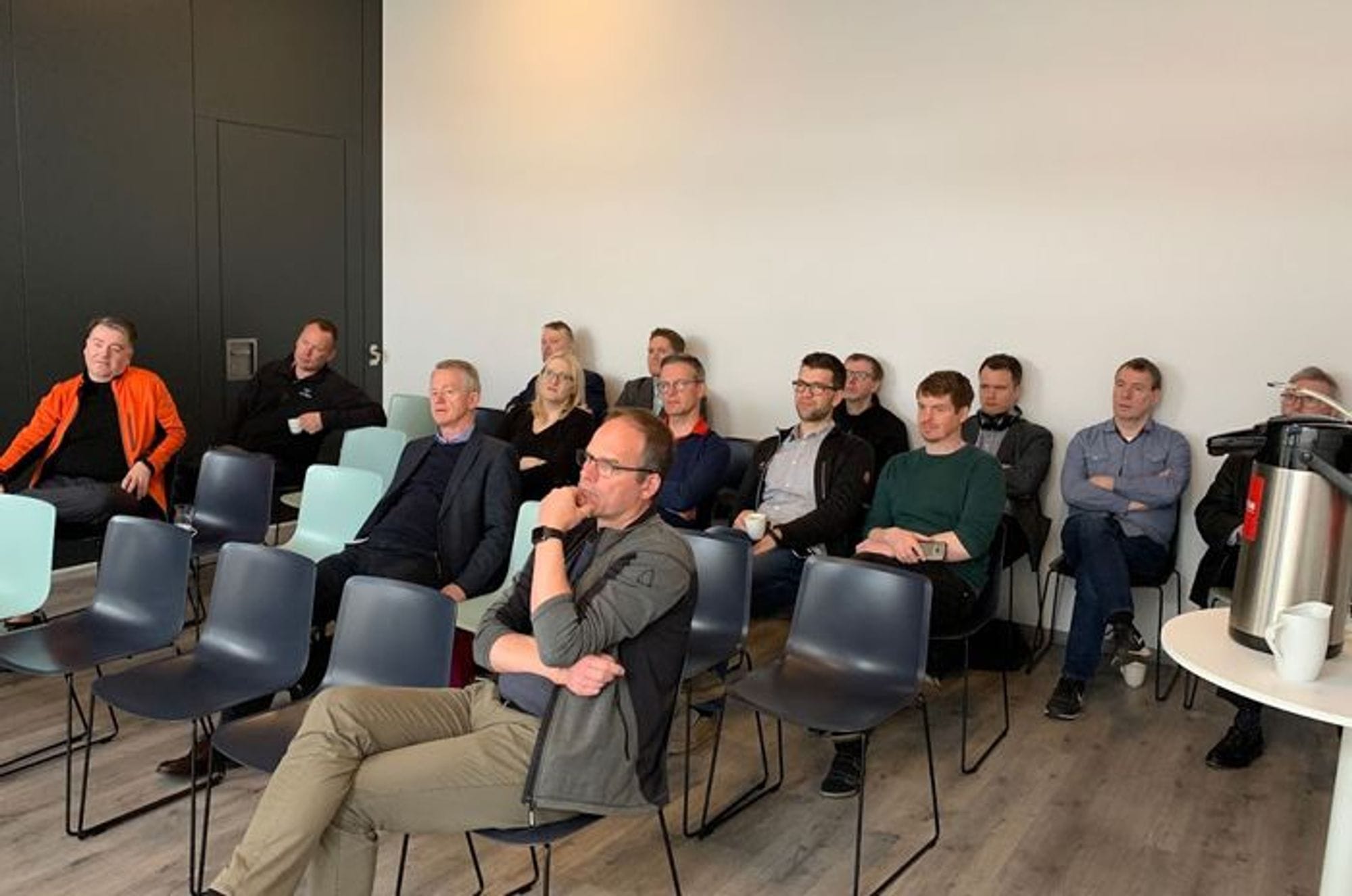 A group of people seated in a meeting room looking straight with great focus
