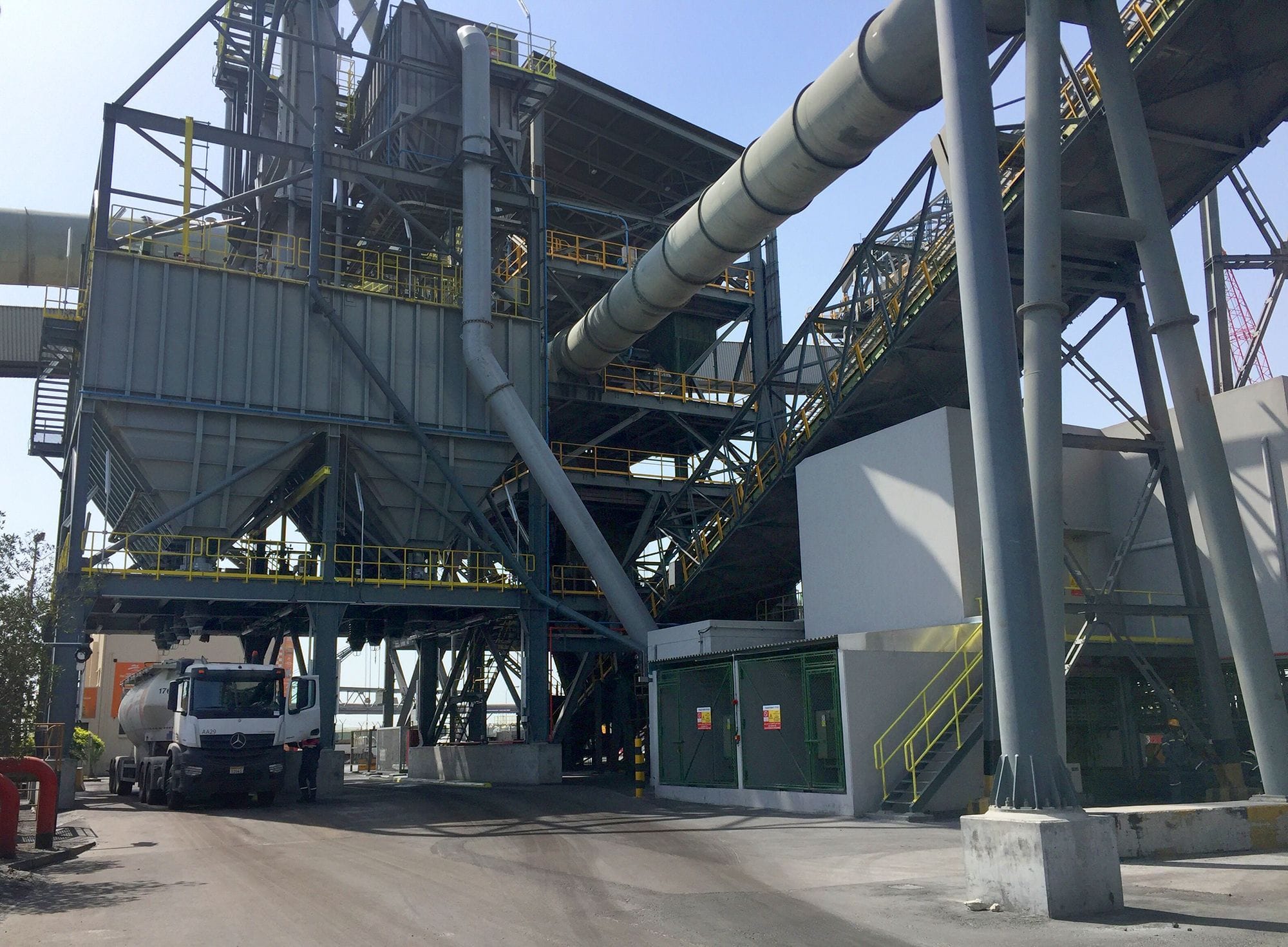 Industrial facility with large pipes and a truck parked at the base