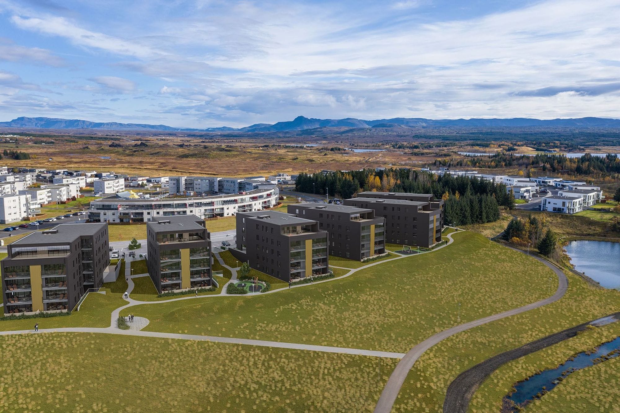 bird eye view of apartment buildings in a green landscape under a partly cloudy sky
