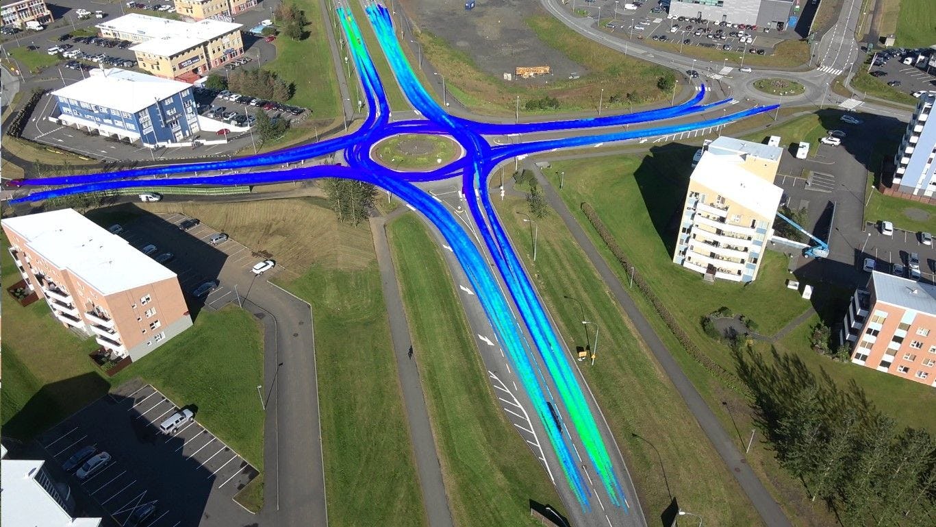 An aerial view of a roundabout with blue traffic flow lines