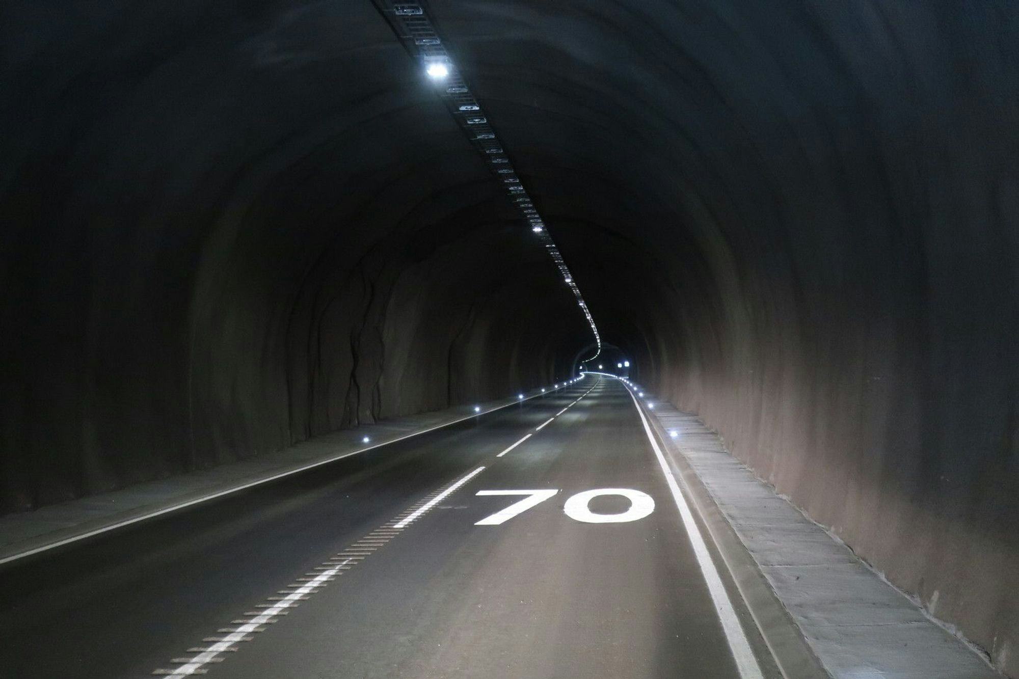 Interior of a well lit tunnel showing the speed limit is 70