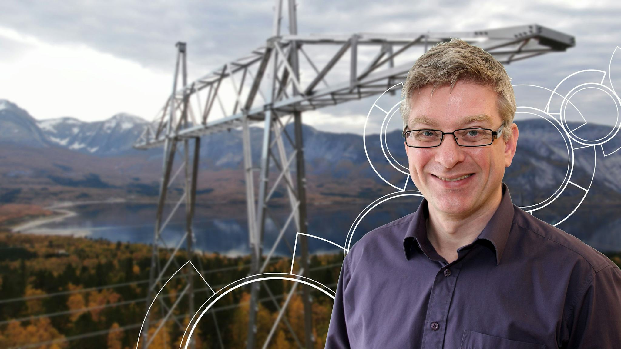 A man with smile superimposed in front of a background showing a large electricity pylon