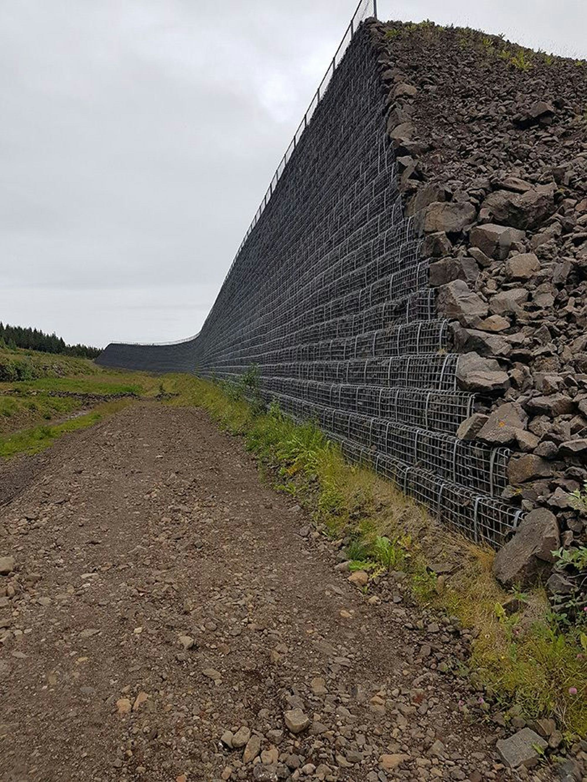 A wall made of wire mesh and filled with rock appeared as a barrier 