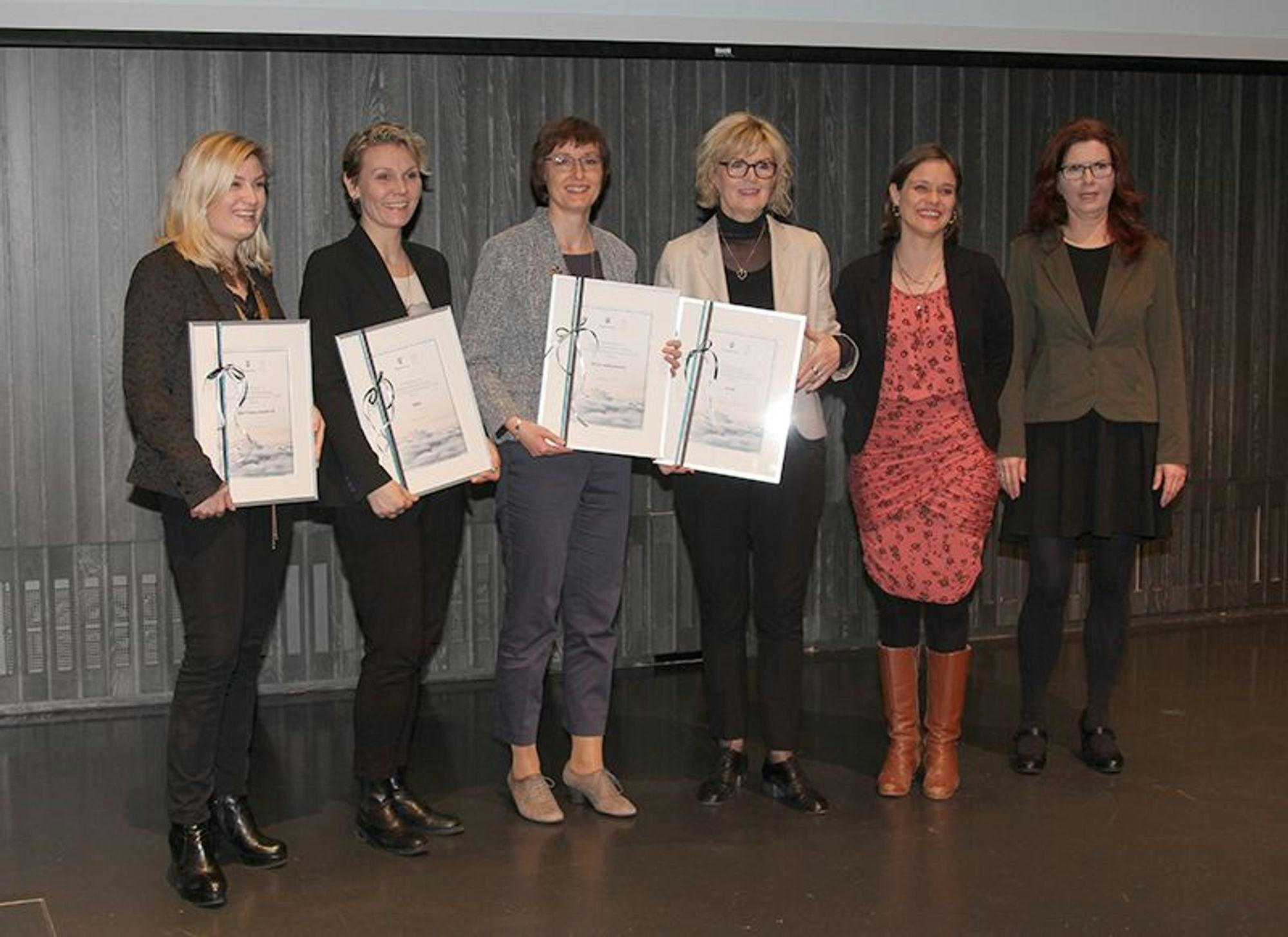 Six women standing together and holding certificates 