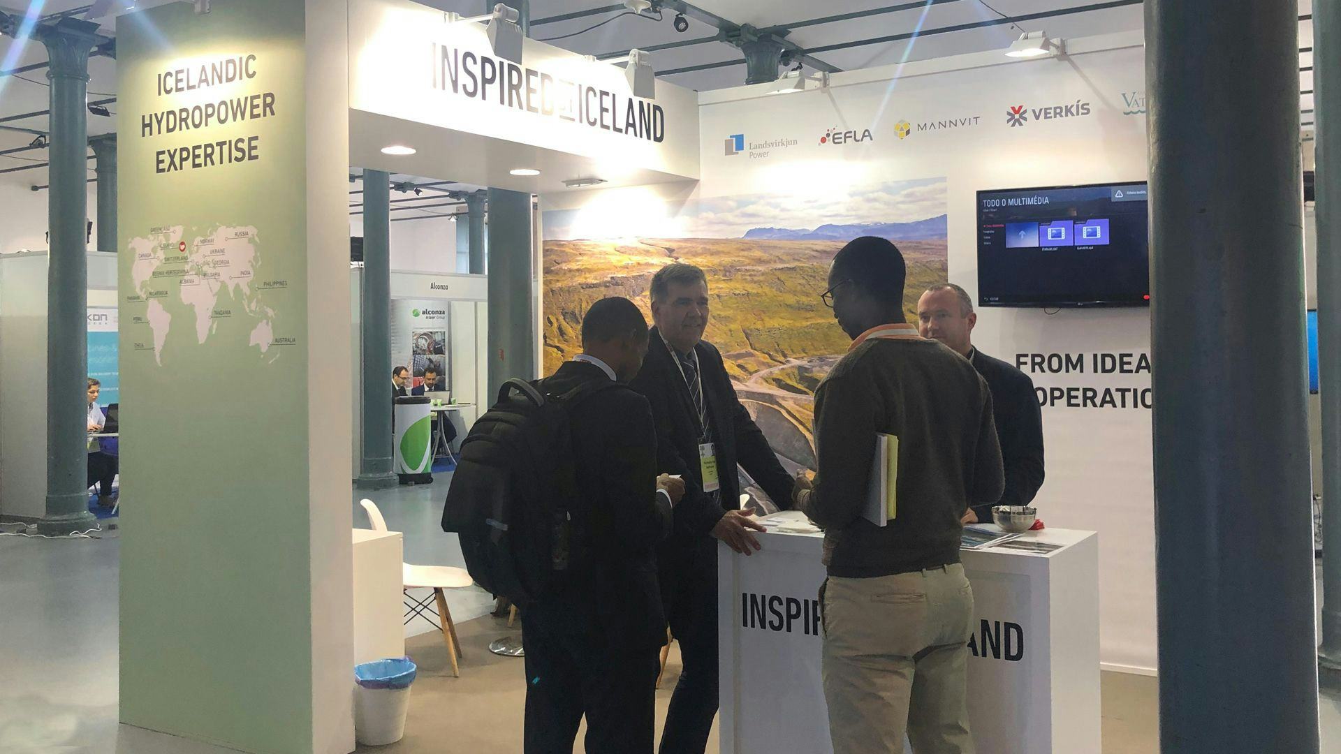 Four men having a discussion in a promotional booth for INSPIREDBYICELAND