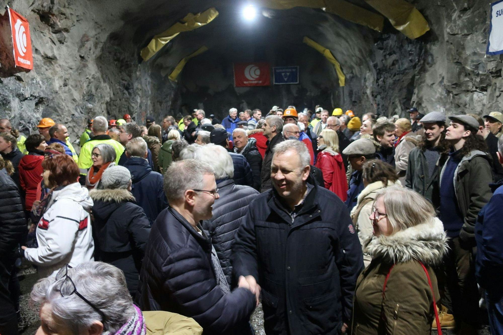 A large group of people gathered inside a tunnel for an event