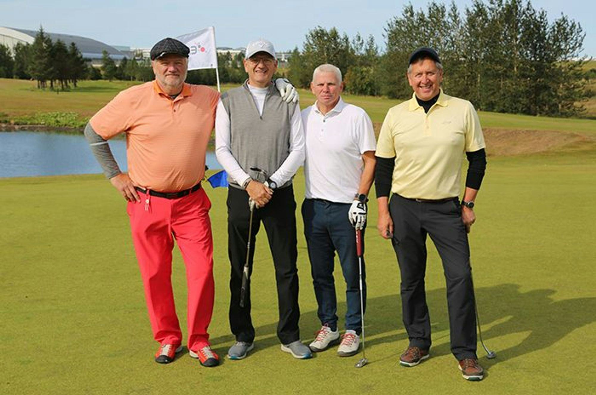 Four men posing on a golf course