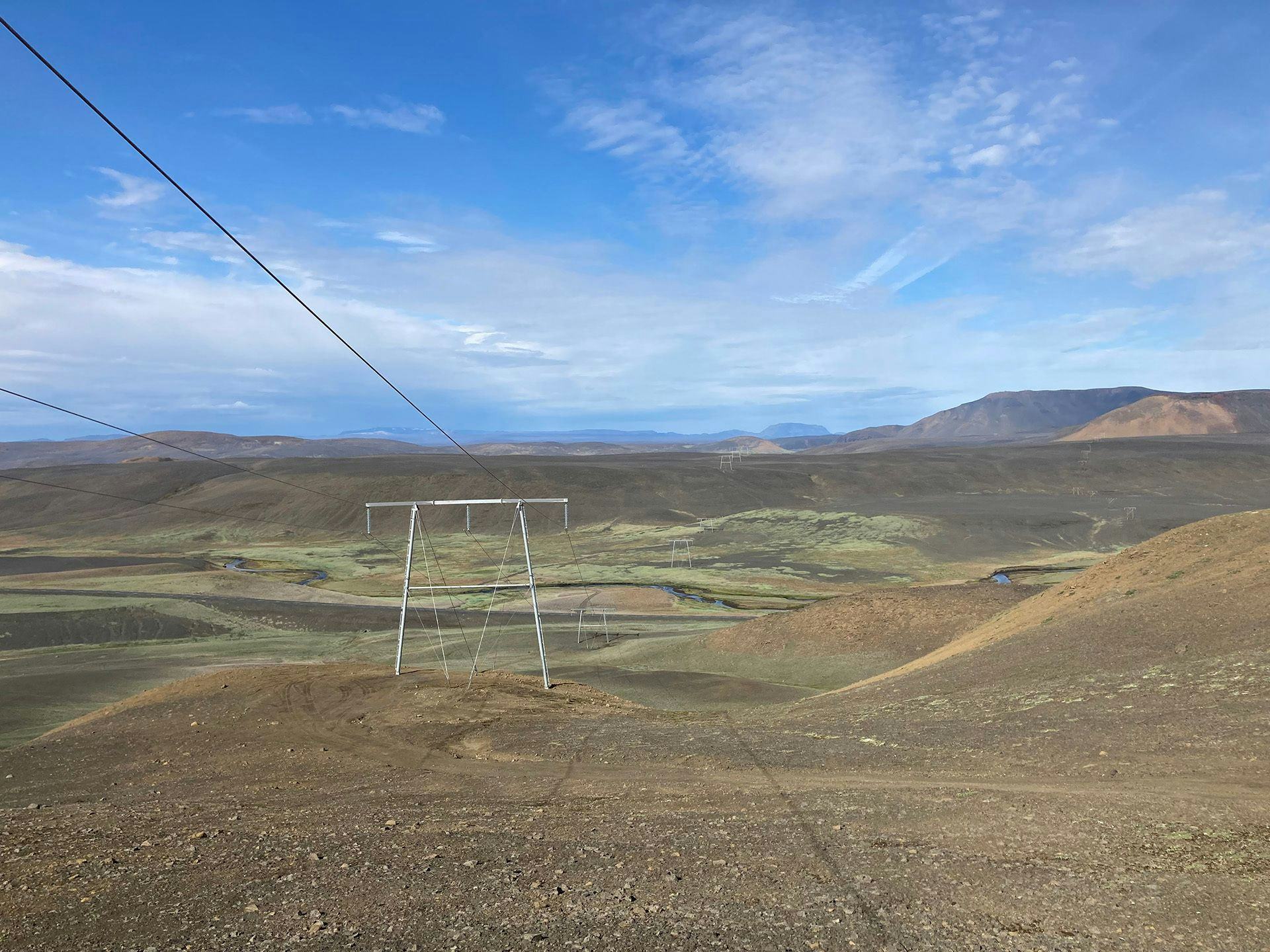 A single electricity pylon centered in a sparse landscape